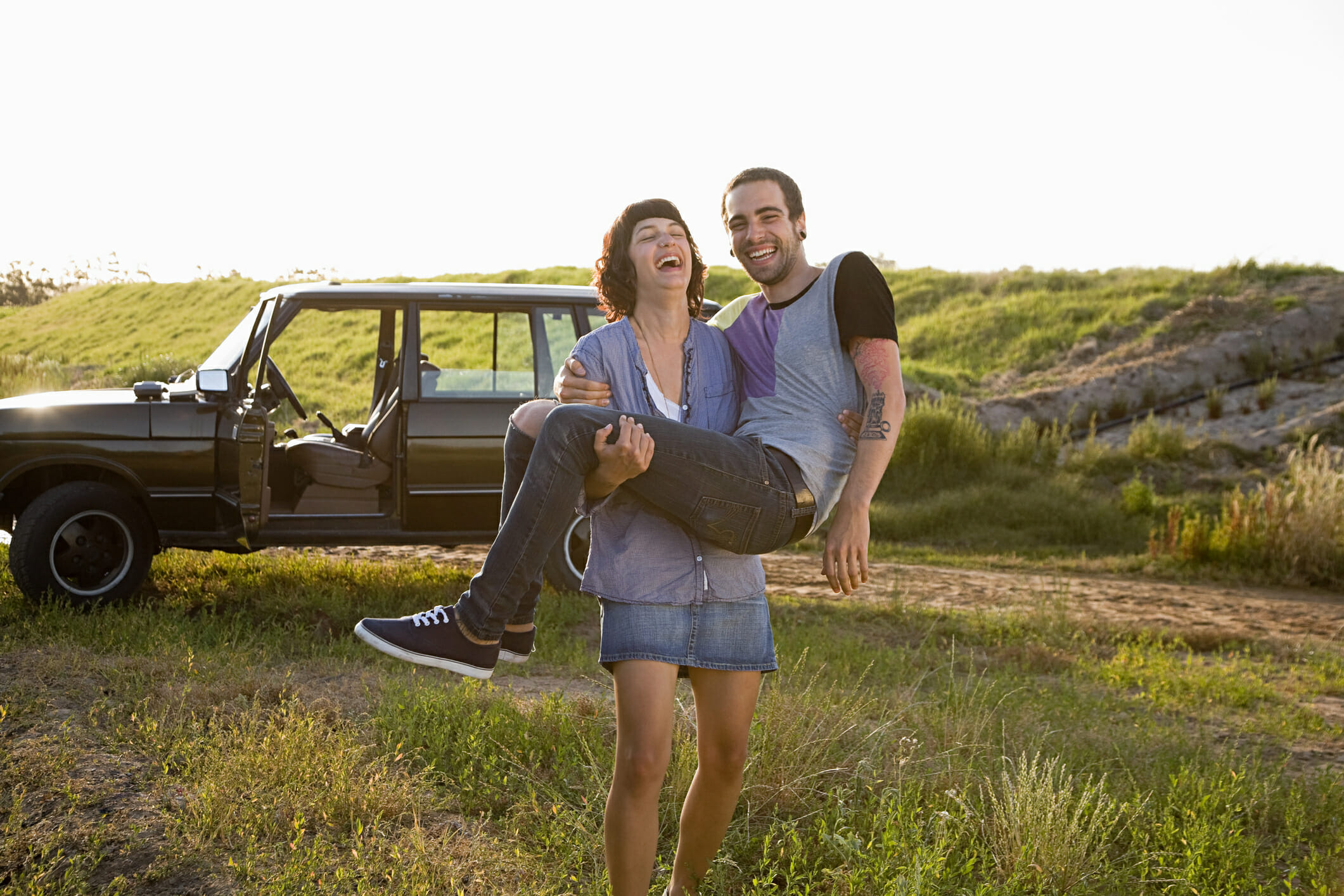 A smiling woman carries her husband