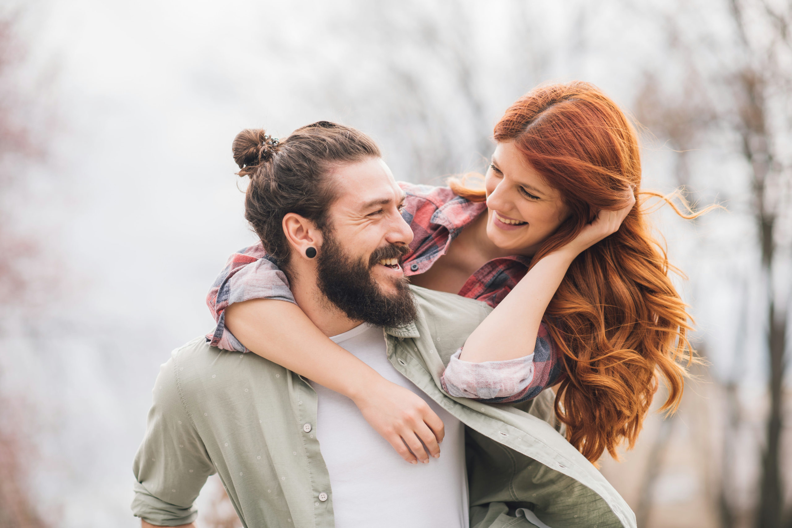 A happy couple embraces outside.