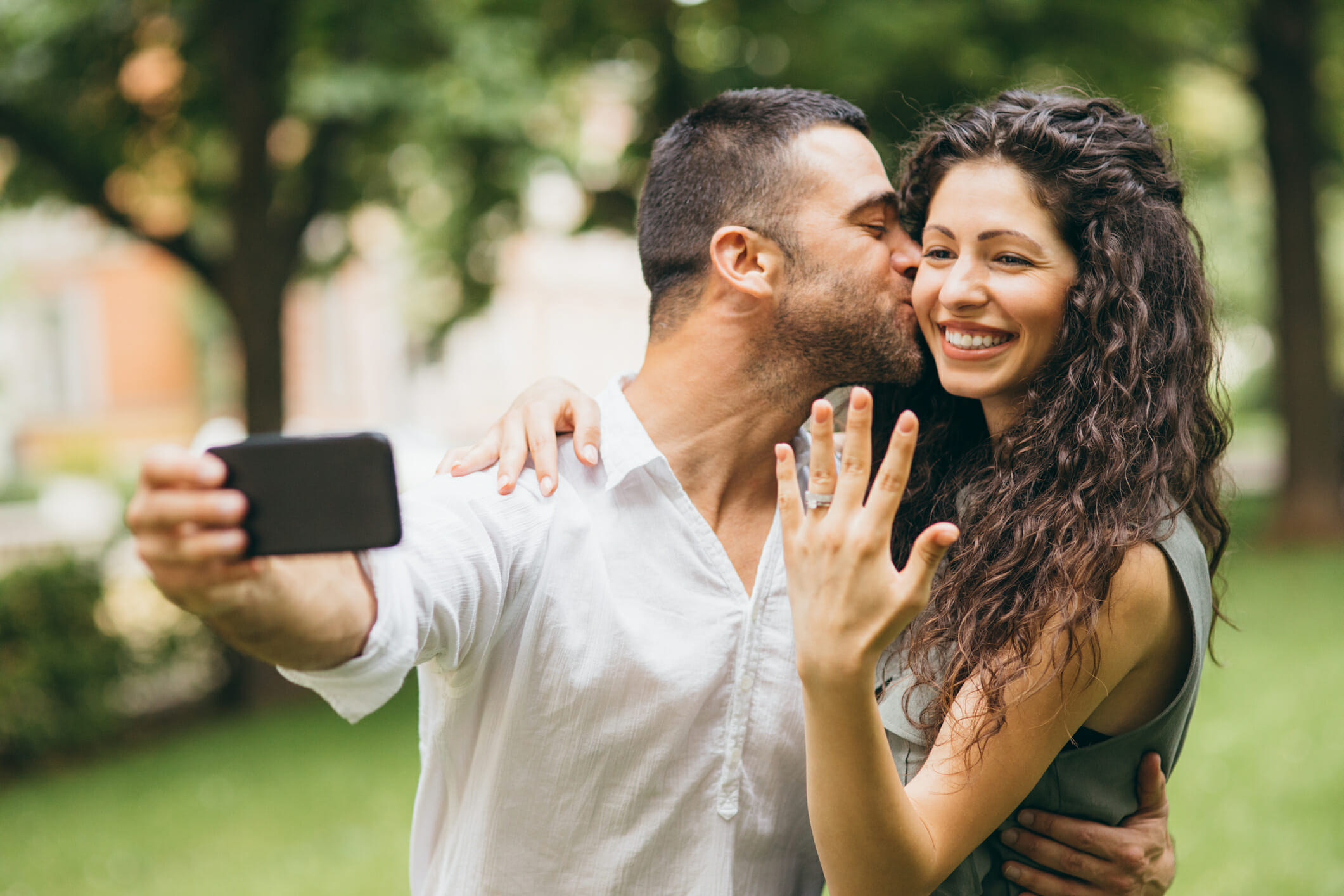 A happy couple poses for a selfie after getting engaged.