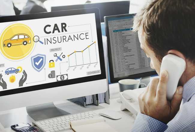 man looking at computer screen as he reads about car insurance