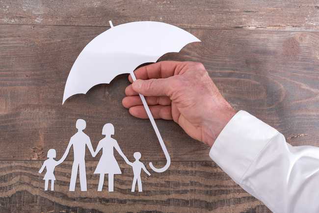 paper cutout of an umbrella held over a family of cut outs