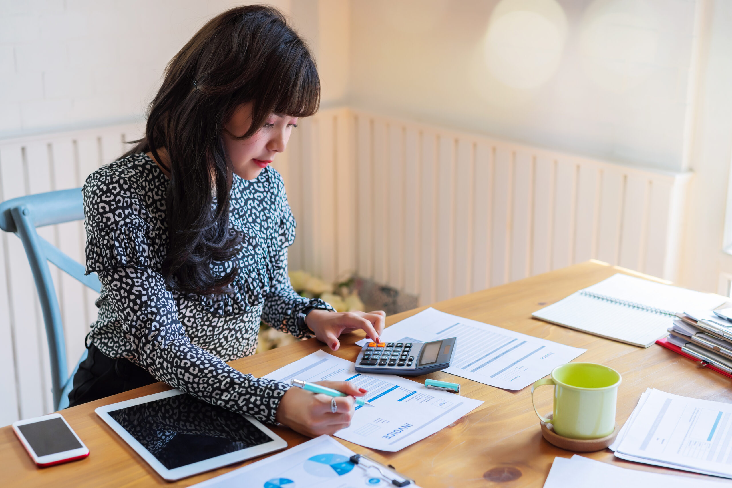 woman at her desk calculating her debt to income ratio