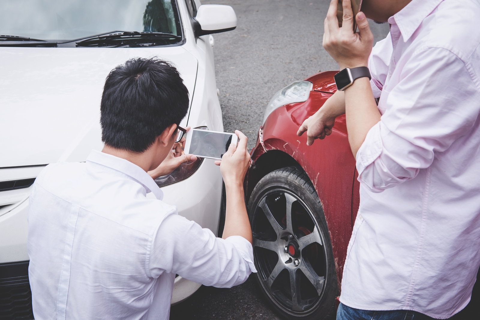 man taking a photo of his damaged car after a car accident