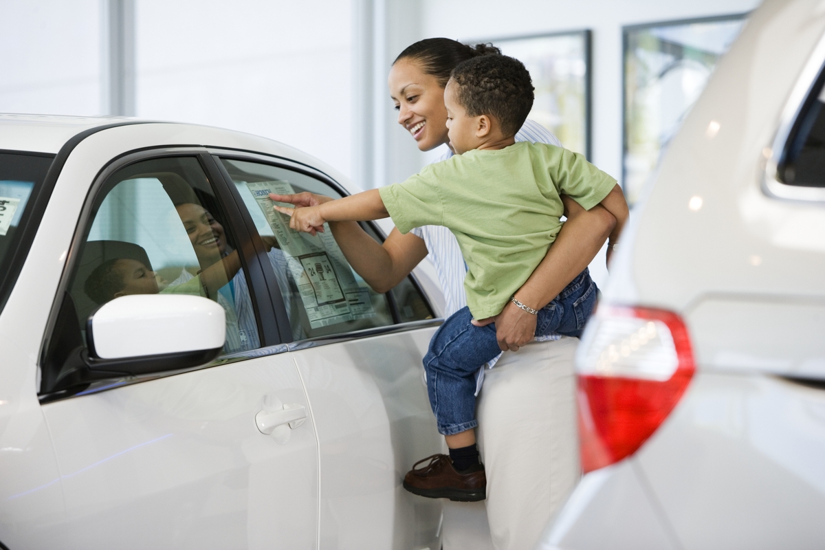 woman considering gap insurance as she shops for a new car with her child